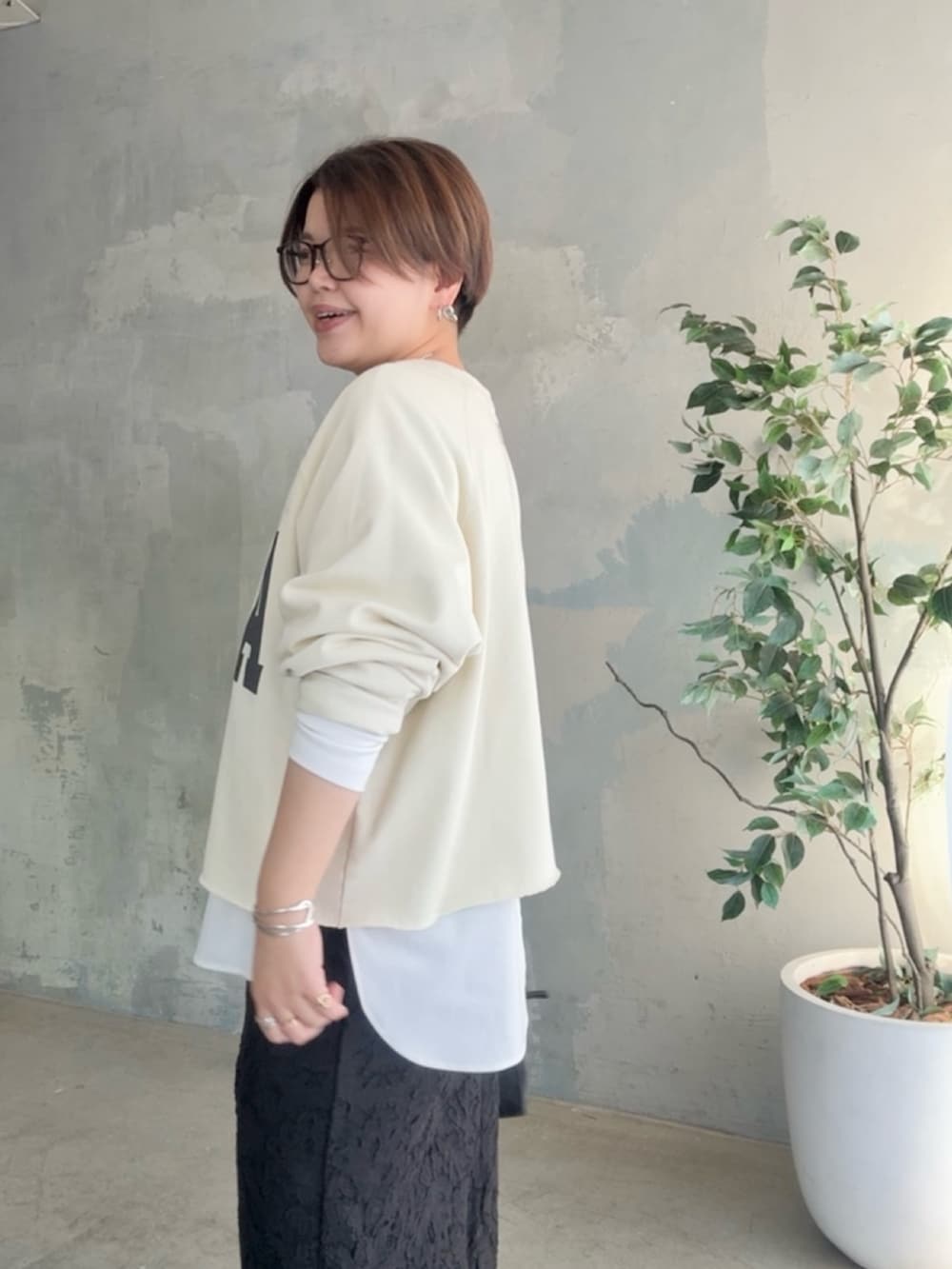 ホワイト系のスウェット、ホワイト系のTシャツ/カットソー、ブラック系のスカートを着用したレディースの冬コーディネートの5枚目の写真