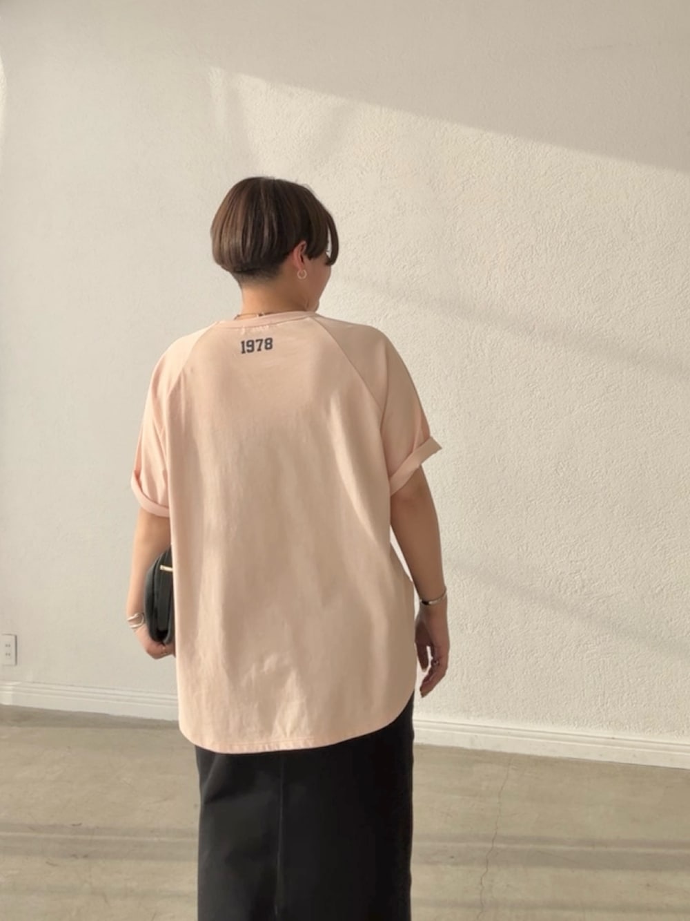 ピンク系のTシャツ/カットソー、ブラック系のスカート、ブラック系のショルダーバッグを着用したレディースの春コーディネートの6枚目の写真