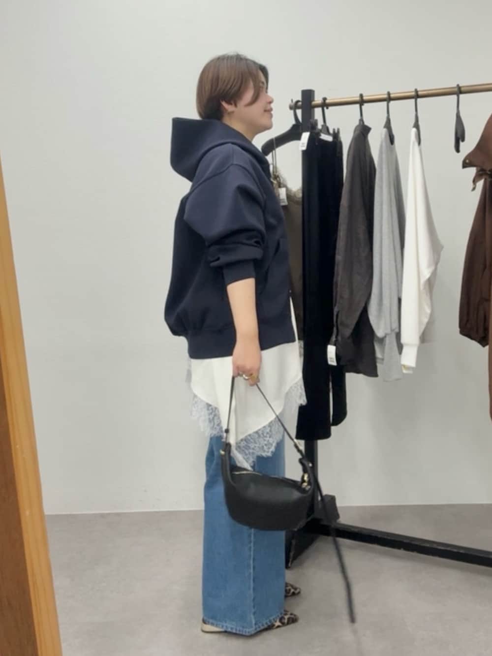 ブルー系のパーカー、ホワイト系のキャミソール、ブルー系のデニムパンツを着用したレディースの春コーディネートの3枚目の写真