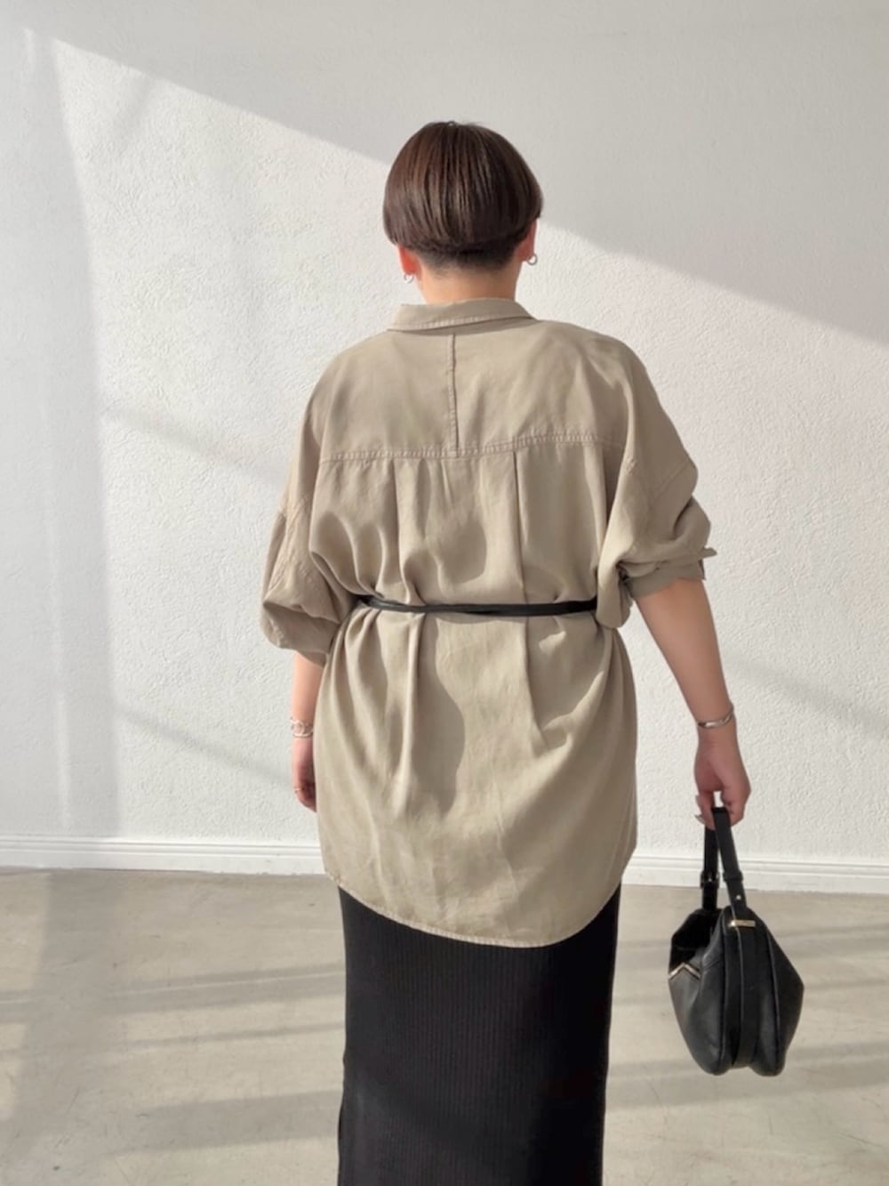 グリーン系のシャツ/ブラウス、ブラック系のワンピース、ブラック系のショルダーバッグを着用したレディースの春コーディネートの6枚目の写真