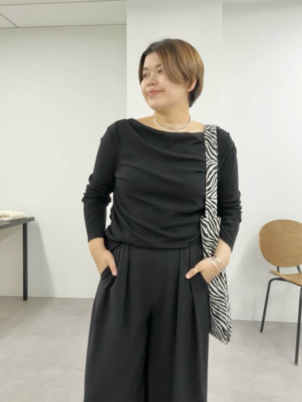 ブラック系のTシャツ/カットソー、ブラック系のスラックスを着用したレディースの春コーディネートの3枚目の写真