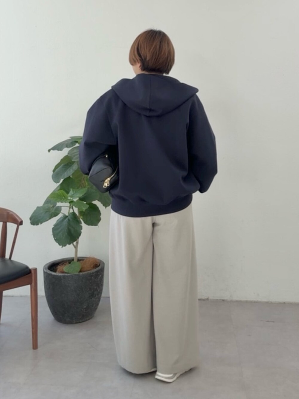 ブルー系のパーカー、ホワイト系のシャツ/ブラウス、ベージュ系のスラックスを着用したレディースの冬コーディネートの3枚目の写真