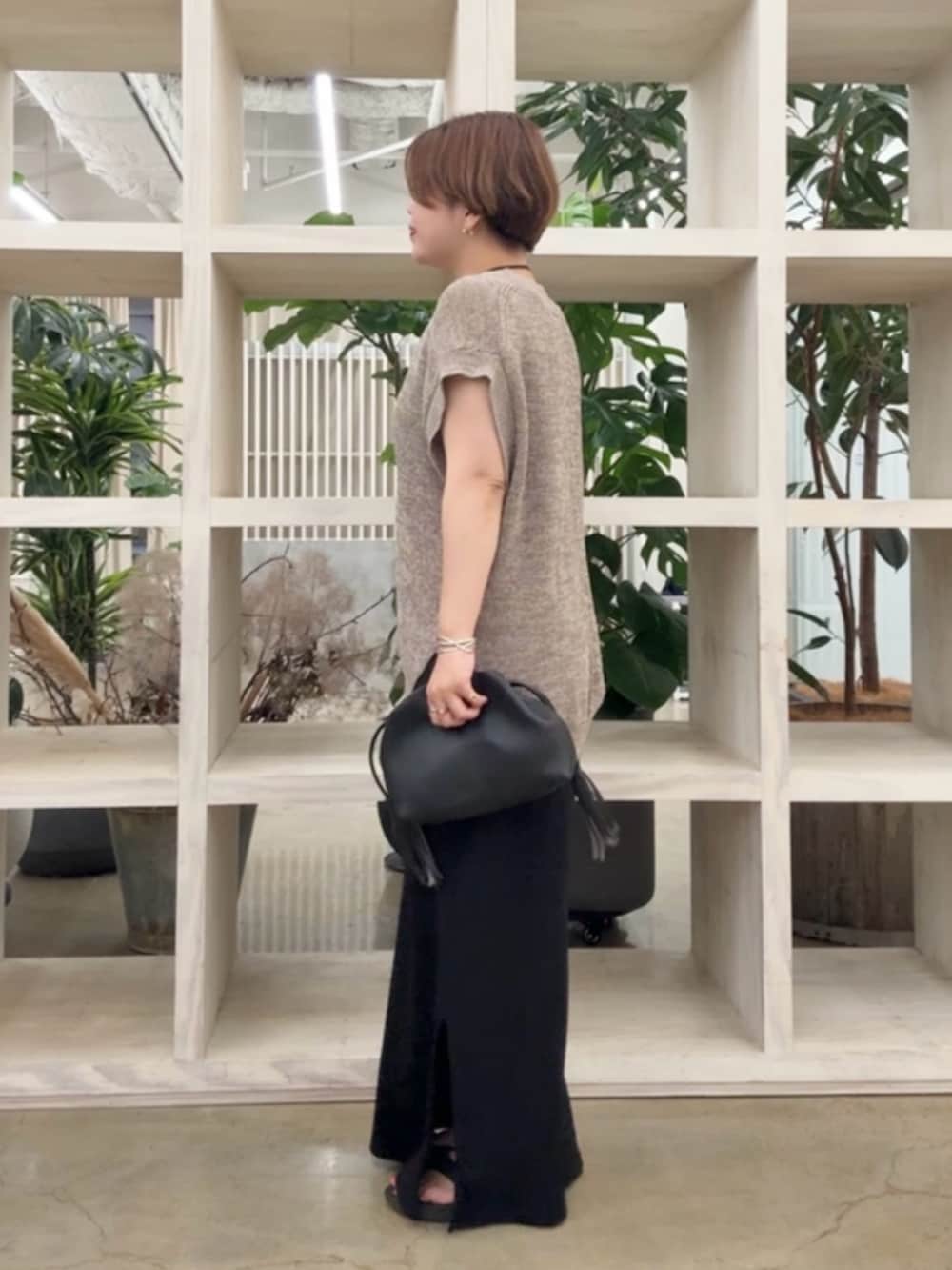 ブラウン系のニット/セーター、ブラック系のワンピースを着用したレディースの夏コーディネートの2枚目の写真