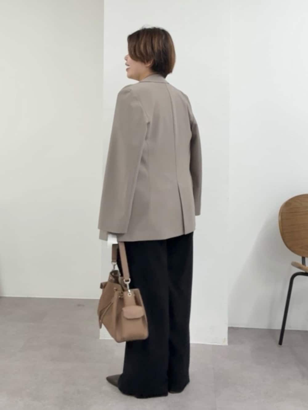 ベージュ系のTシャツ/カットソー、ブラウン系のテーラードジャケット、ブラック系のスラックスを着用したレディースの春コーディネートの2枚目の写真