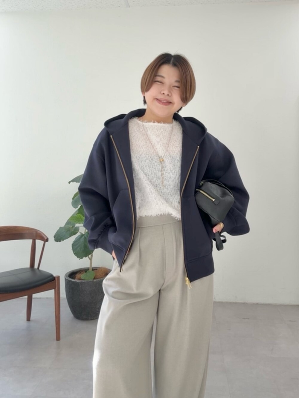 ブルー系のパーカー、ホワイト系のシャツ/ブラウス、ベージュ系のスラックスを着用したレディースの冬コーディネートの4枚目の写真