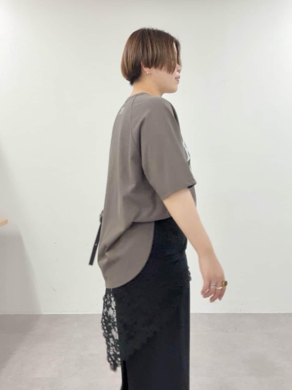 ブラウン系のTシャツ/カットソー、ブラック系のスラックス、ブラック系のストール/ショールを着用したレディースの春コーディネートの5枚目の写真