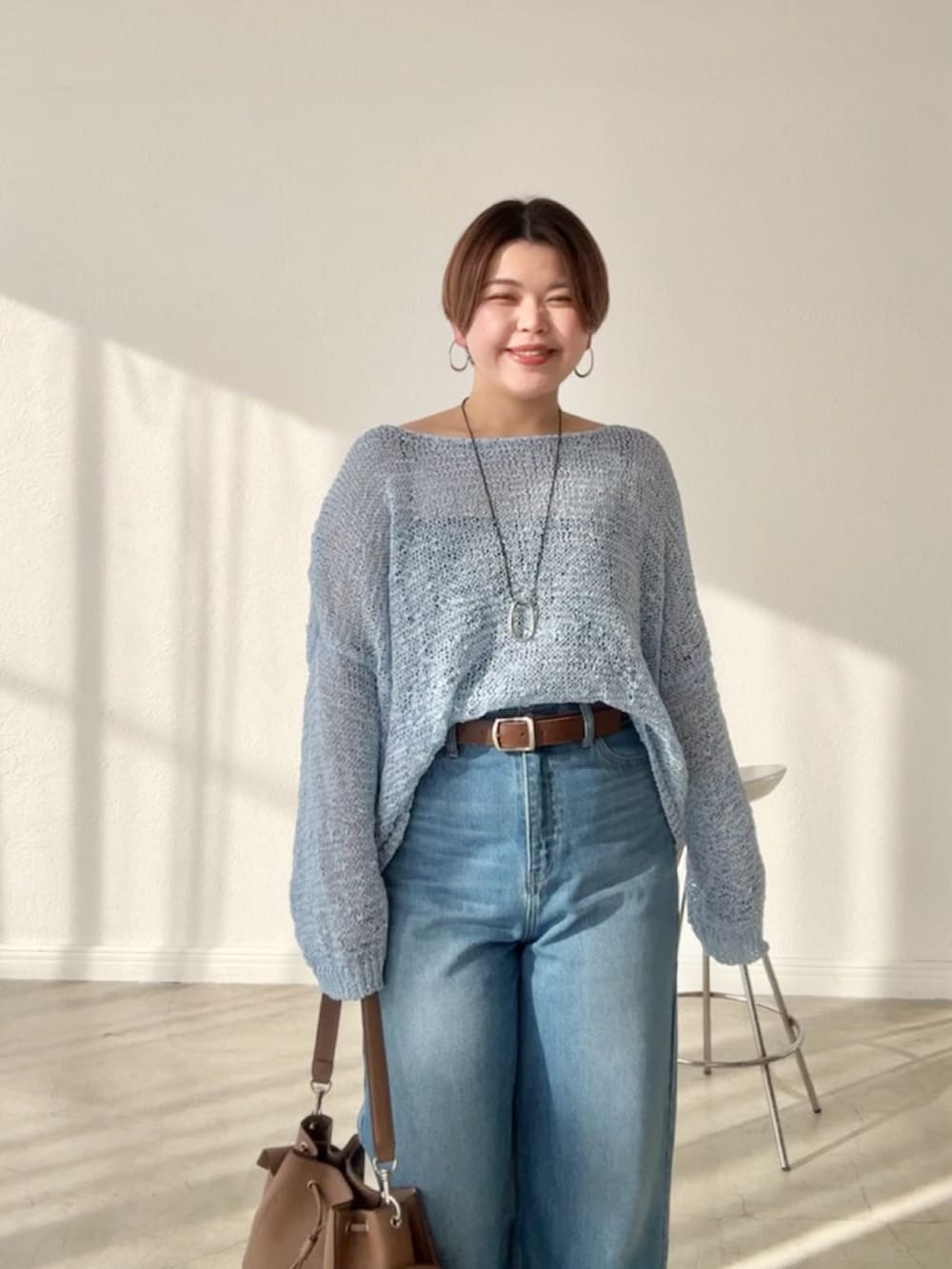 ブルー系のデニムパンツ、ブルー系のニット/セーターを着用したレディースの春コーディネートの4枚目の写真