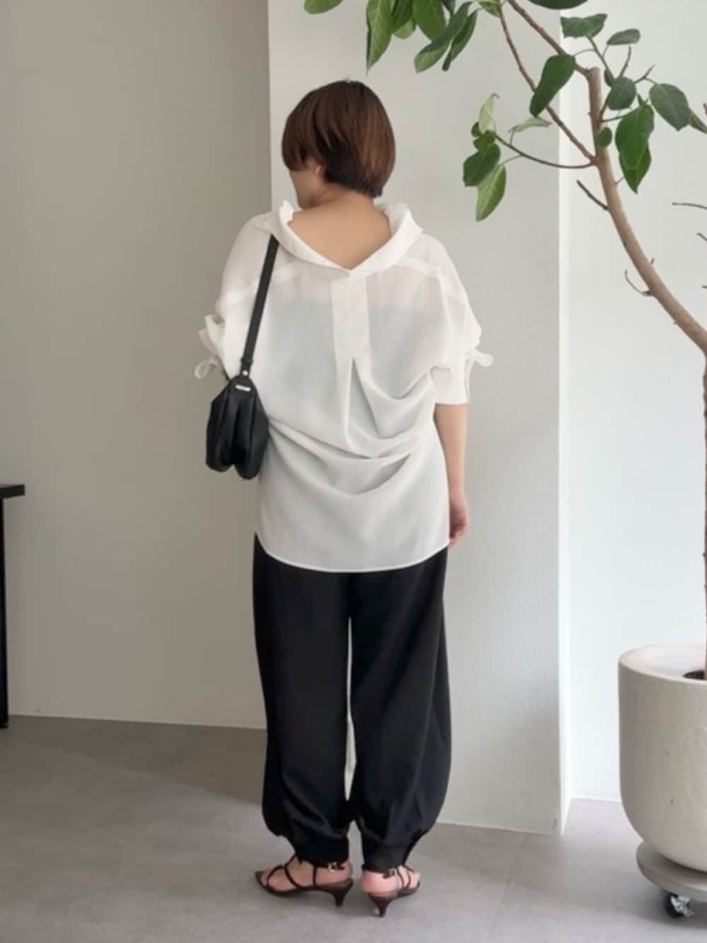 ホワイト系のシャツ/ブラウス、ブラック系のその他パンツ、ブラック系のショルダーバッグを着用したレディースの春コーディネートの3枚目の写真