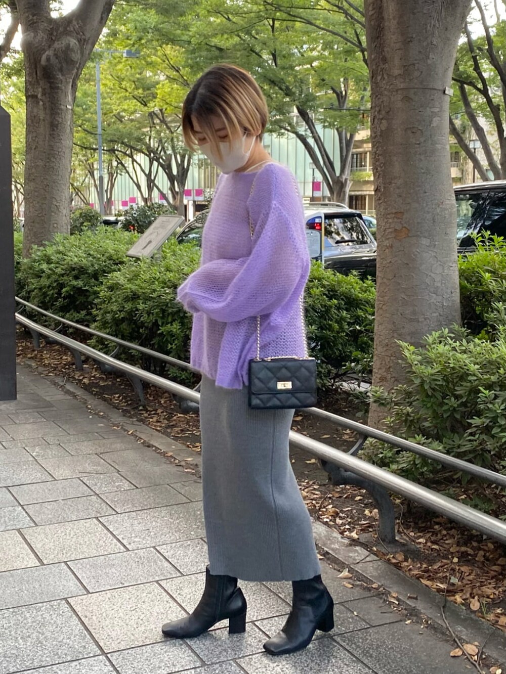 パープル系のニット/セーター、グレー系のスカート、ブラック系のブーツを着用したレディースの秋コーディネートの2枚目の写真