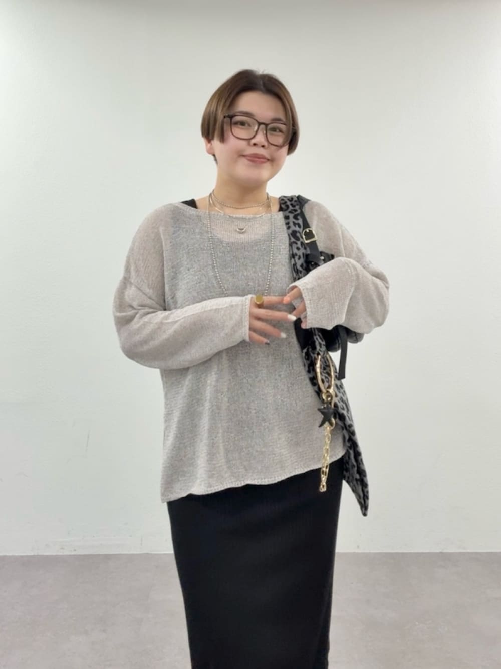 グレー系のニット/セーター、ブラック系のワンピースを着用したレディースの春コーディネートの4枚目の写真