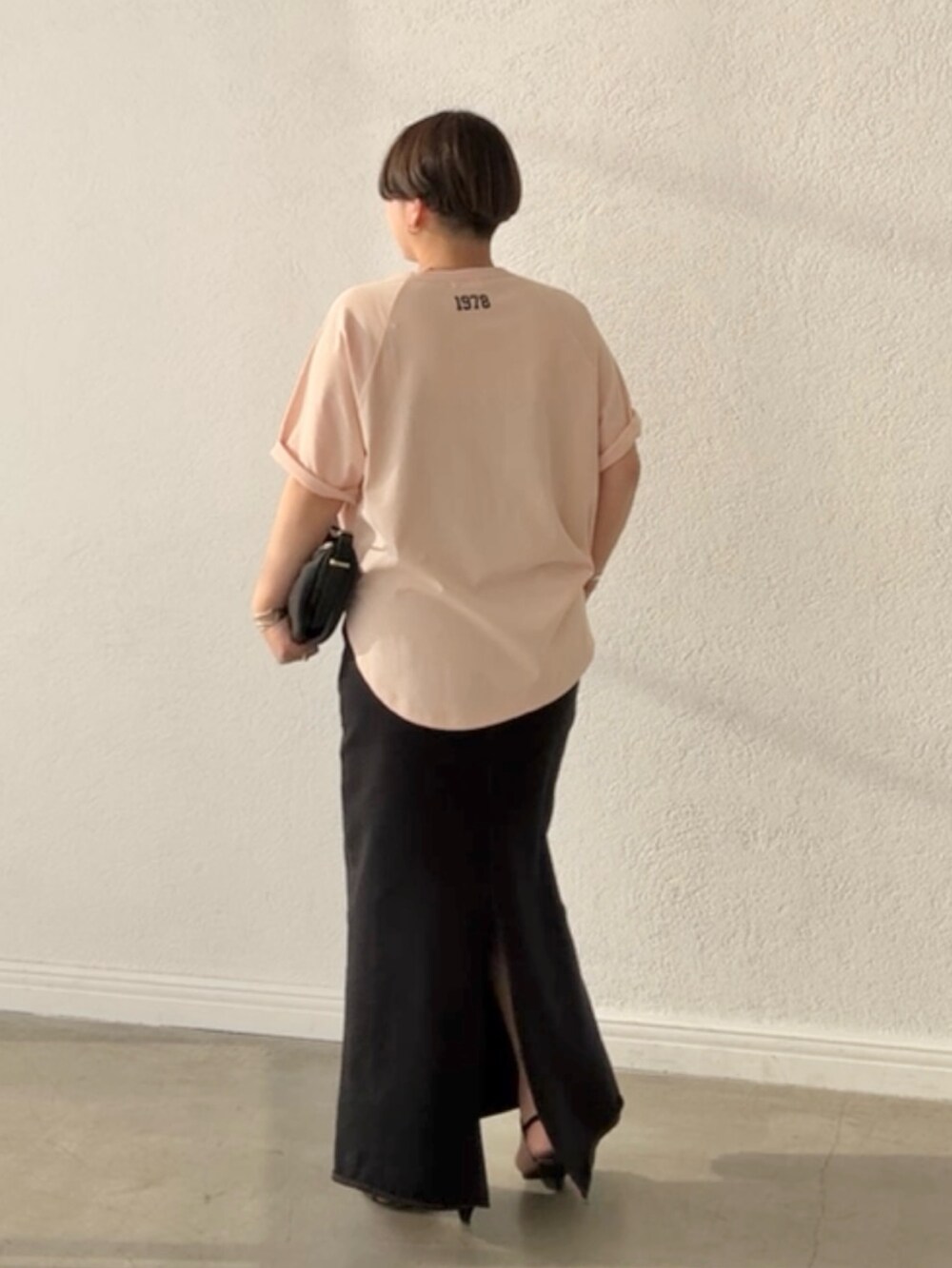 ピンク系のTシャツ/カットソー、ブラック系のスカート、ブラック系のショルダーバッグを着用したレディースの春コーディネートの3枚目の写真