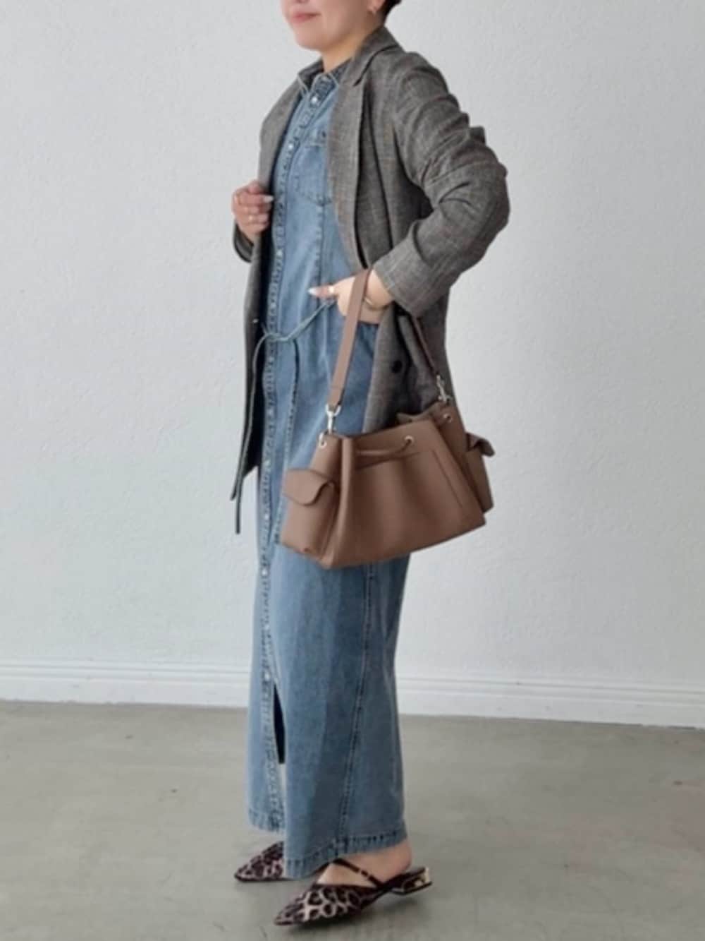 ブルー系のワンピース、ブラック系のテーラードジャケットを着用したレディースの春コーディネートの2枚目の写真