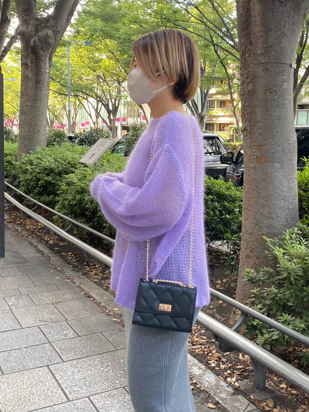 パープル系のニット/セーター、グレー系のスカート、ブラック系のブーツを着用したレディースの秋コーディネートの5枚目の写真