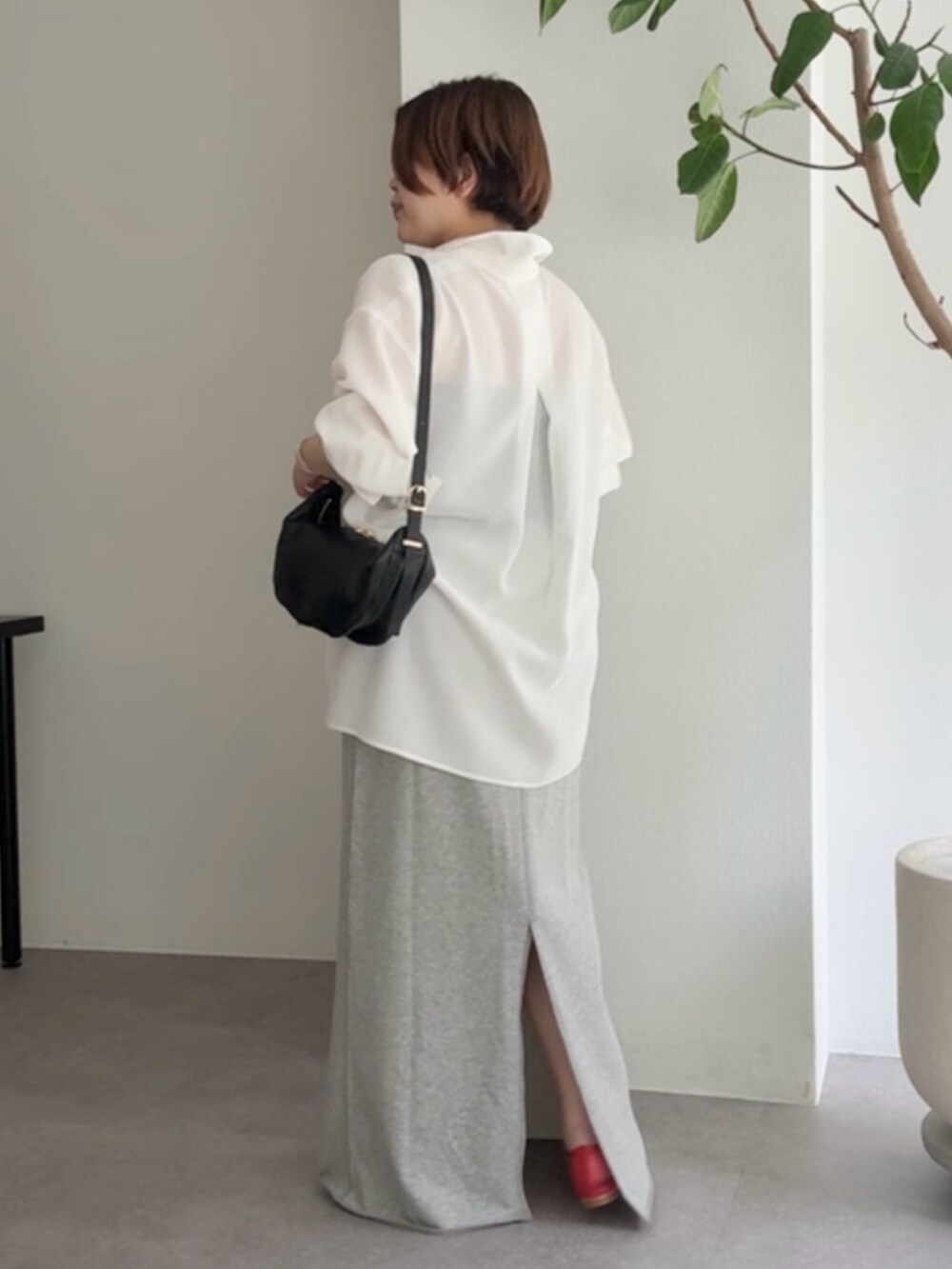 ホワイト系のシャツ/ブラウス、グレー系のスカート、ブラック系のショルダーバッグを着用したレディースの春コーディネートの3枚目の写真