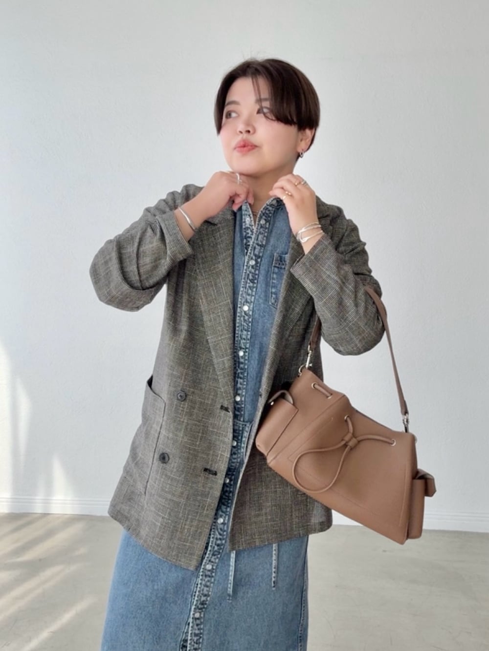 ブルー系のワンピース、ブラック系のテーラードジャケットを着用したレディースの春コーディネートの4枚目の写真