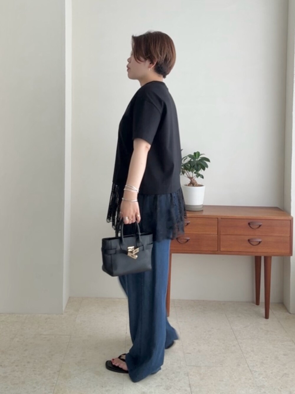 ブラック系のTシャツ/カットソー、ブルー系のデニムパンツを着用したレディースの夏コーディネートの2枚目の写真