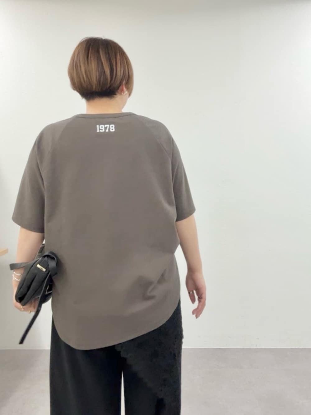 ブラウン系のTシャツ/カットソー、ブラック系のスラックス、ブラック系のストール/ショールを着用したレディースの春コーディネートの6枚目の写真