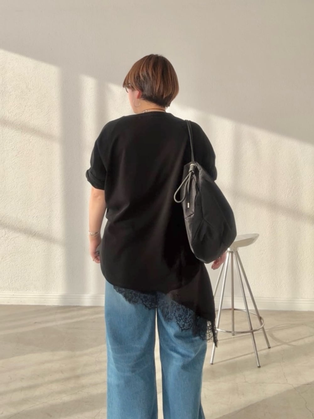 ブラック系のTシャツ/カットソー、ブラック系のキャミソール、ブルー系のデニムパンツを着用したレディースの春コーディネートの4枚目の写真