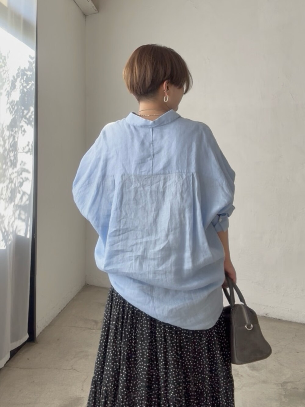 ブルー系のシャツ/ブラウス、ブラック系のスカートを着用したレディースの夏コーディネートの4枚目の写真