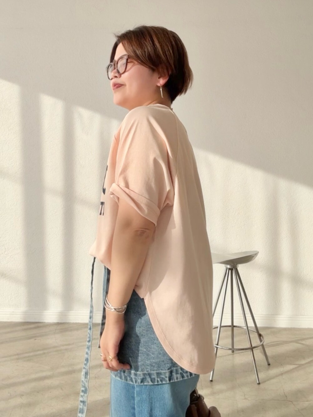 ピンク系のTシャツ/カットソー、ブルー系のデニムスカート、ブルー系のデニムパンツを着用したレディースの春コーディネートの5枚目の写真