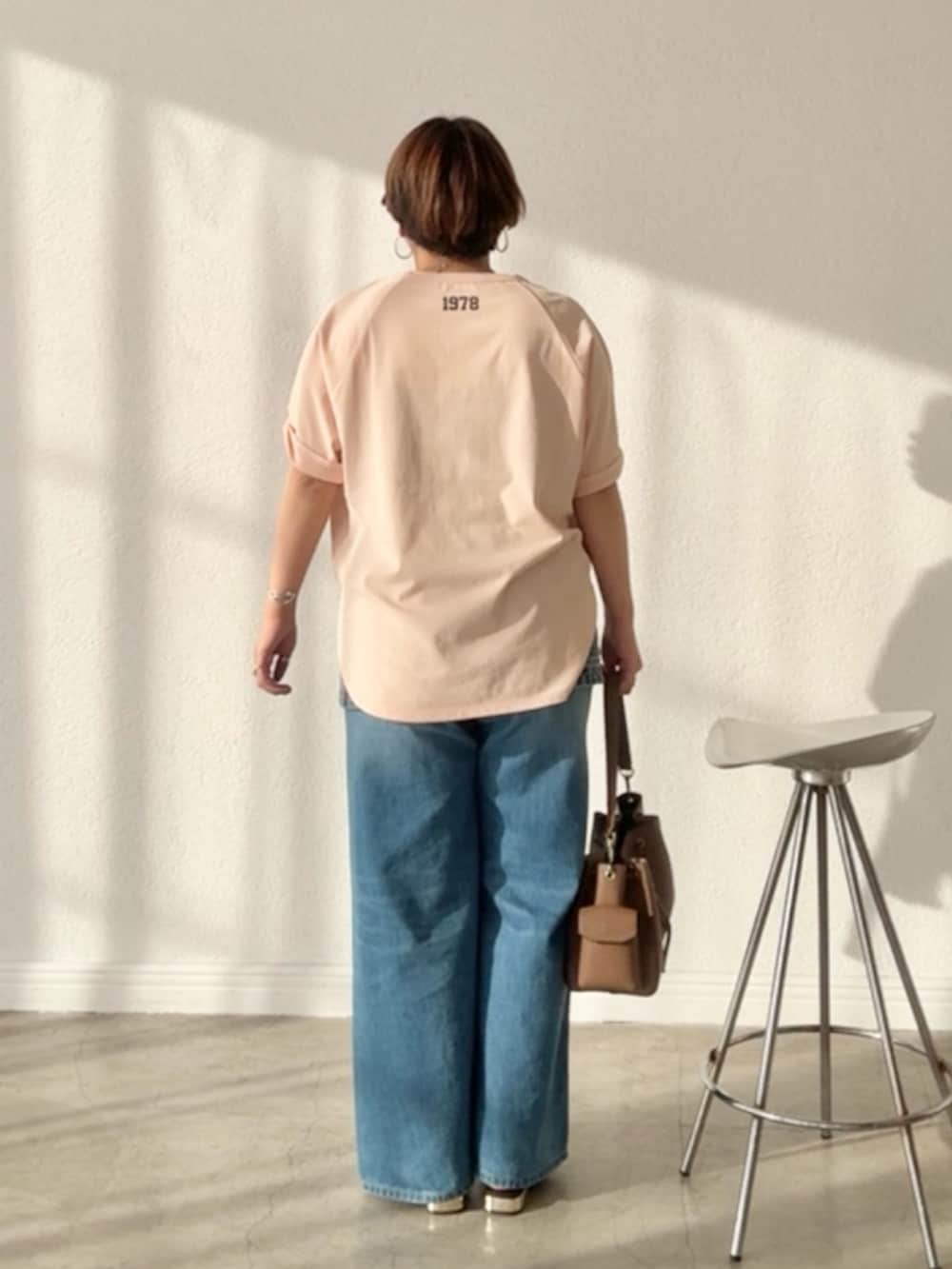 ピンク系のTシャツ/カットソー、ブルー系のデニムスカート、ブルー系のデニムパンツを着用したレディースの春コーディネートの3枚目の写真