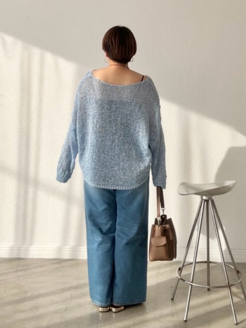 ブルー系のデニムパンツ、ブルー系のニット/セーターを着用したレディースの春コーディネートの2枚目の写真