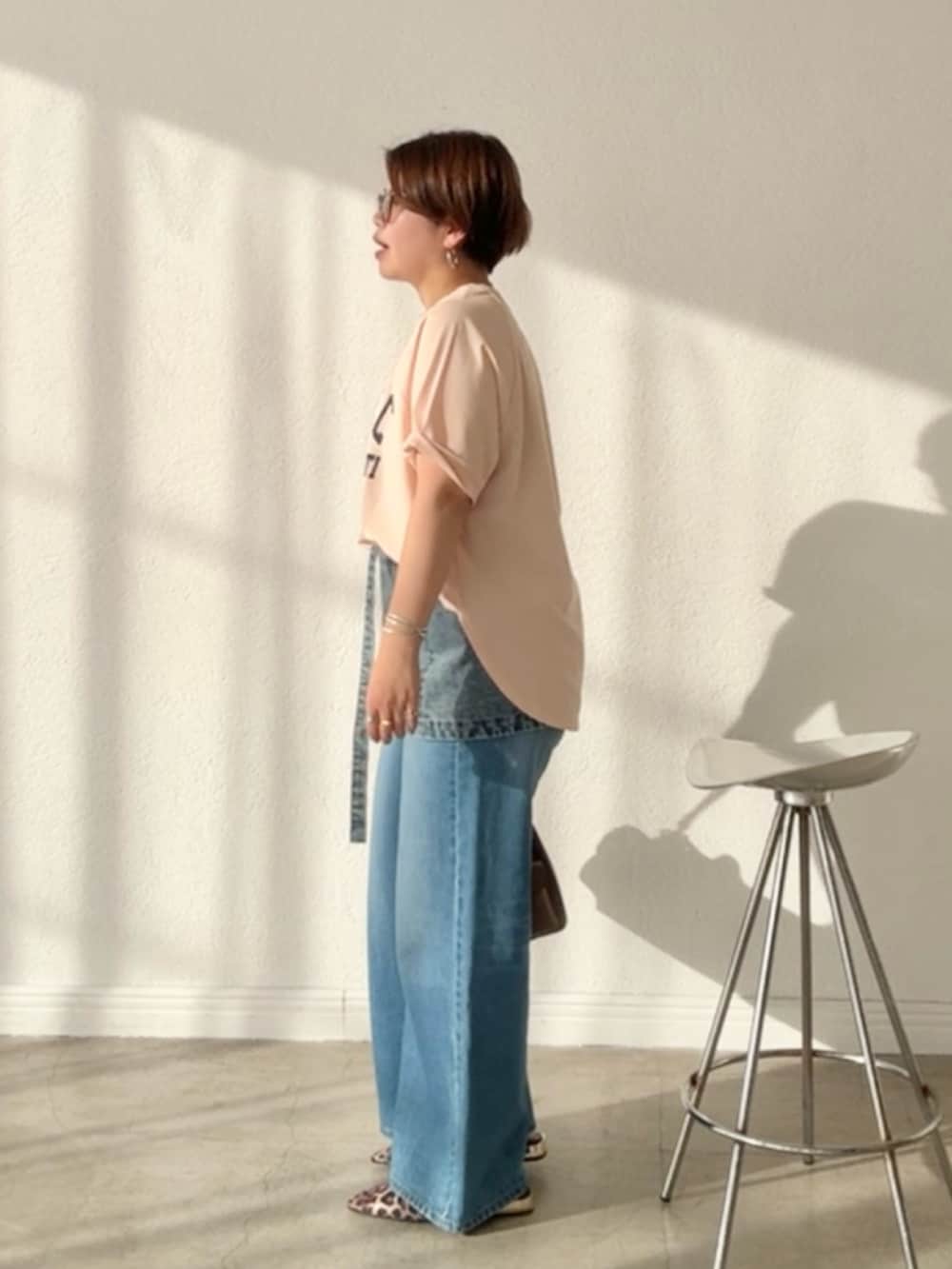 ピンク系のTシャツ/カットソー、ブルー系のデニムスカート、ブルー系のデニムパンツを着用したレディースの春コーディネートの2枚目の写真