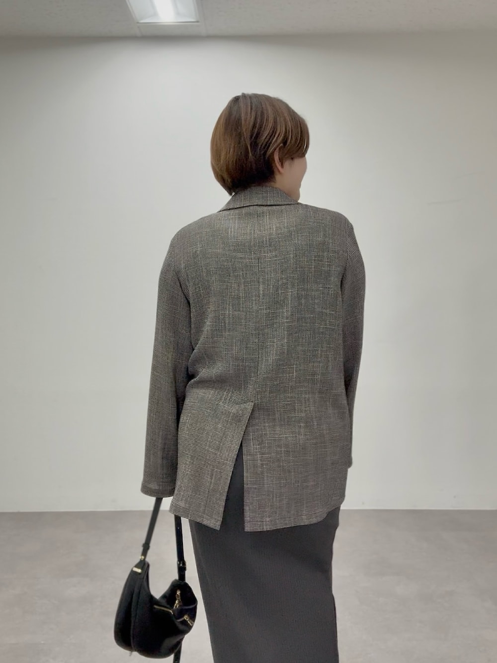 グレー系のワンピース、ブラック系のテーラードジャケットを着用したレディースの春コーディネートの4枚目の写真