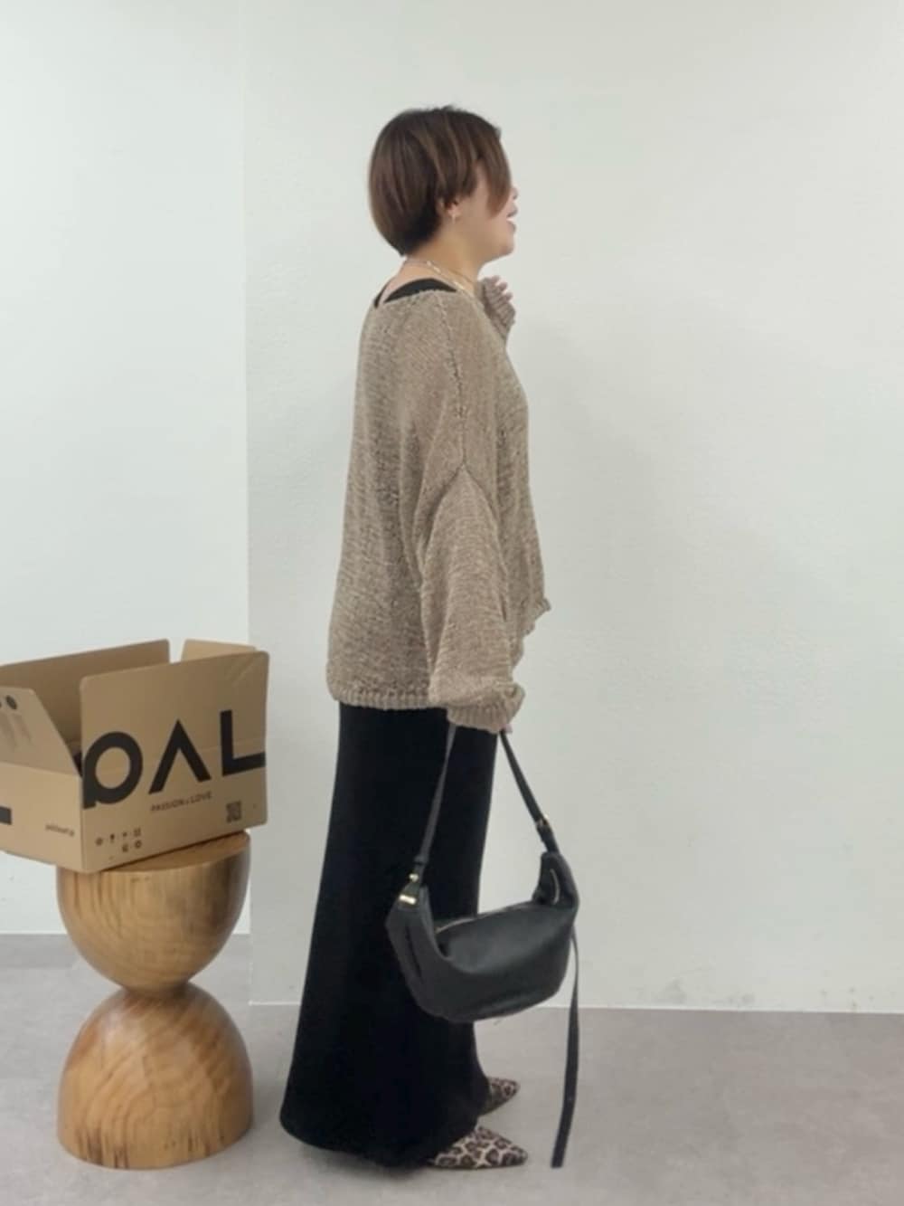 ブラウン系のニット/セーター、ブラック系のワンピースを着用したレディースの冬コーディネートの2枚目の写真