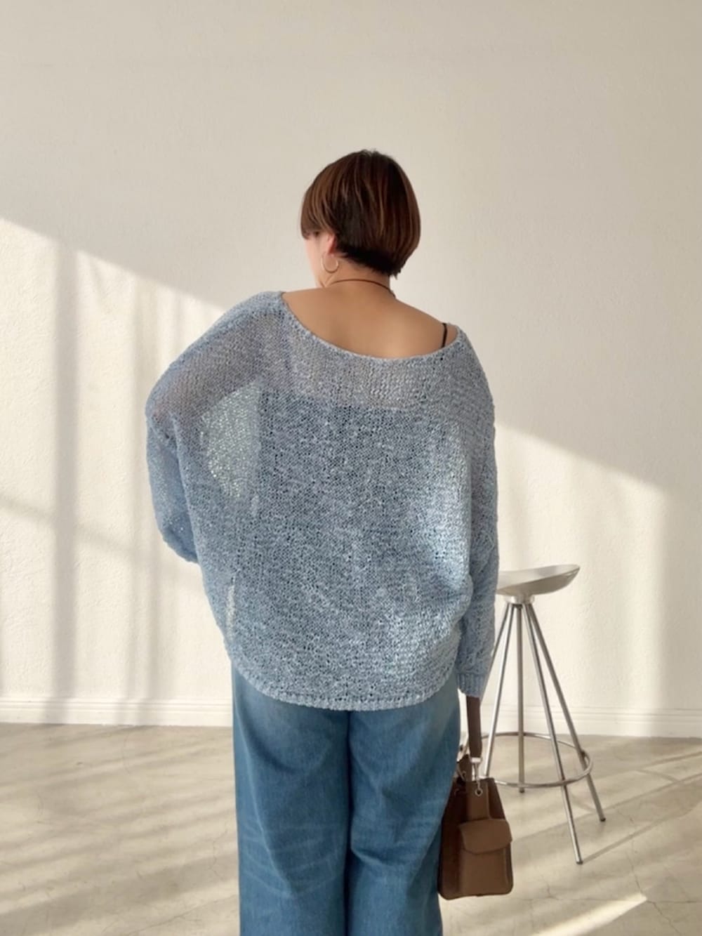 ブルー系のデニムパンツ、ブルー系のニット/セーターを着用したレディースの春コーディネートの6枚目の写真