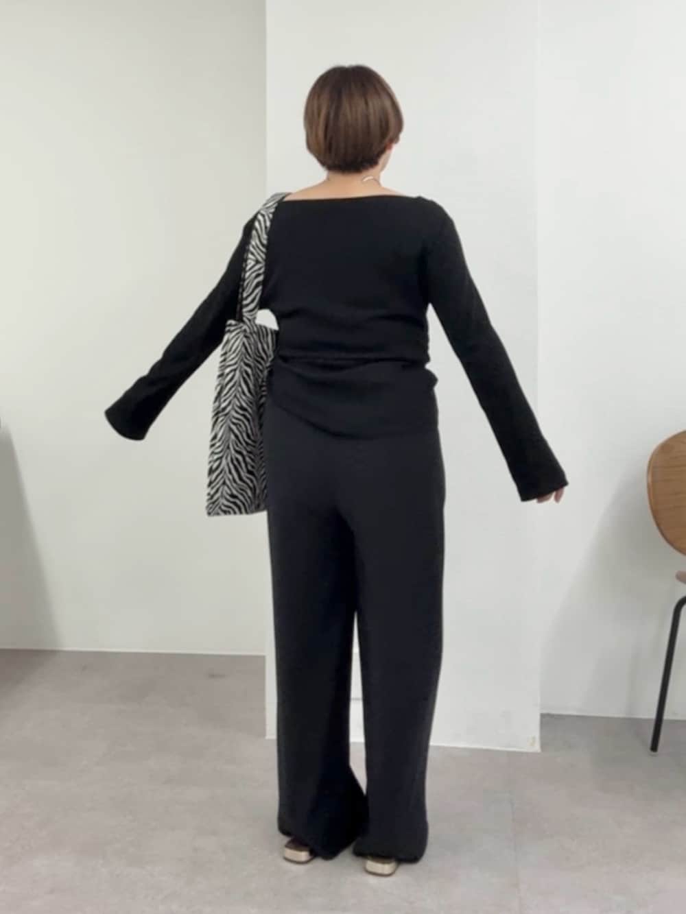 ブラック系のTシャツ/カットソー、ブラック系のスラックスを着用したレディースの春コーディネートの2枚目の写真