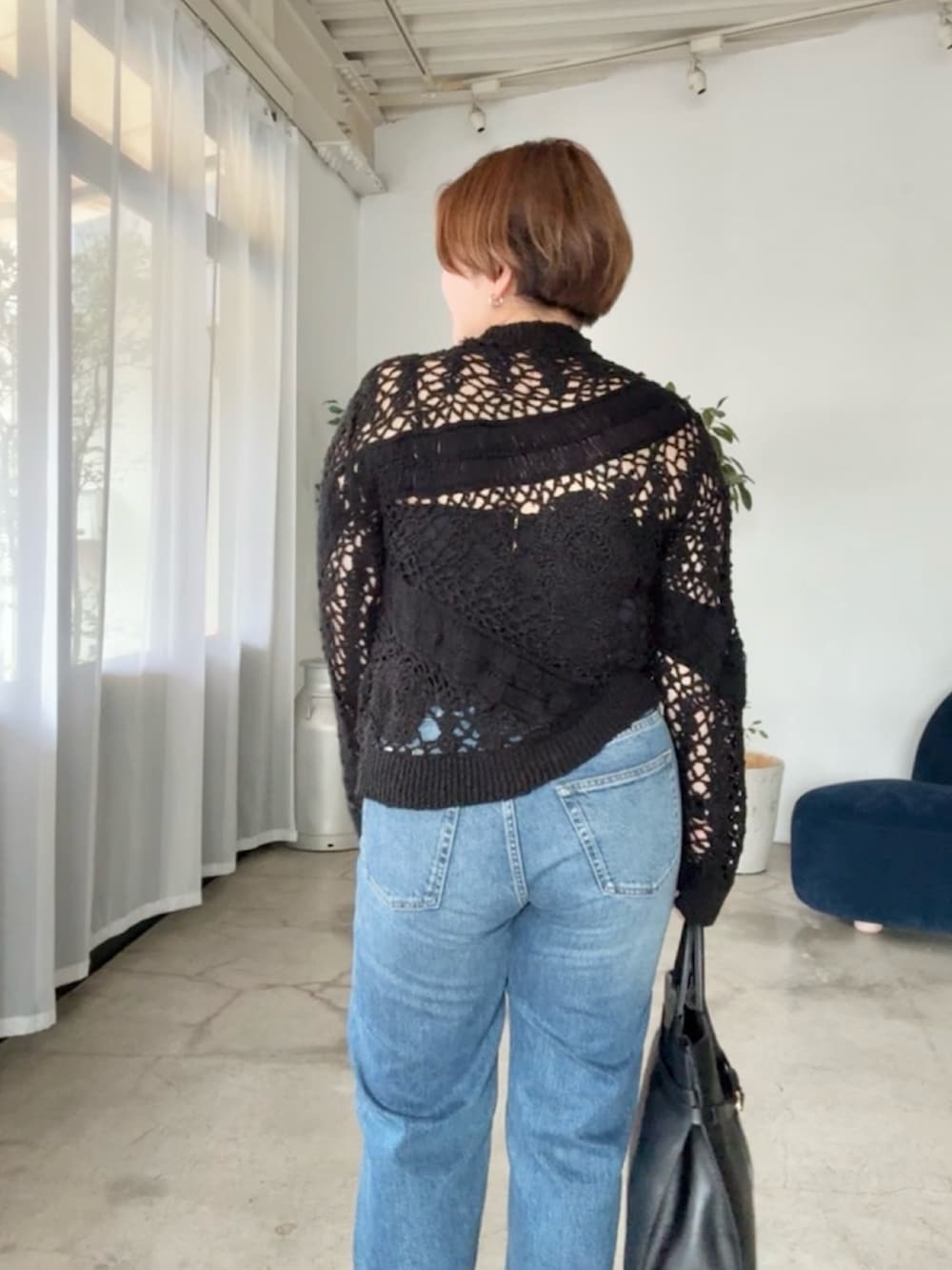 ブルー系のデニムパンツ、ブラック系のニット/セーターを着用したレディースの夏コーディネートの4枚目の写真