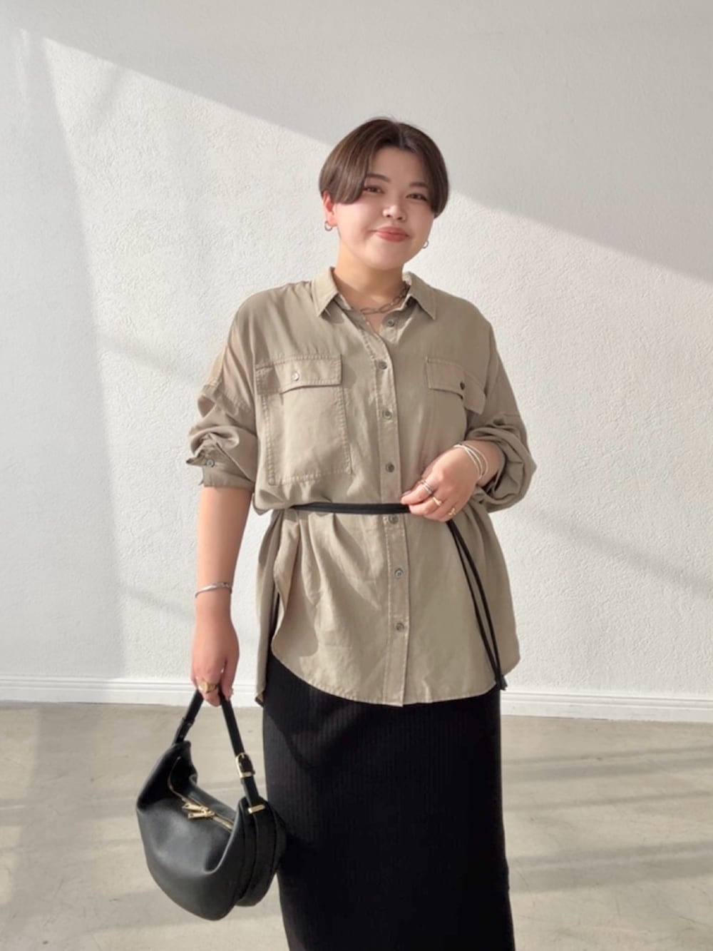 グリーン系のシャツ/ブラウス、ブラック系のワンピース、ブラック系のショルダーバッグを着用したレディースの春コーディネートの4枚目の写真