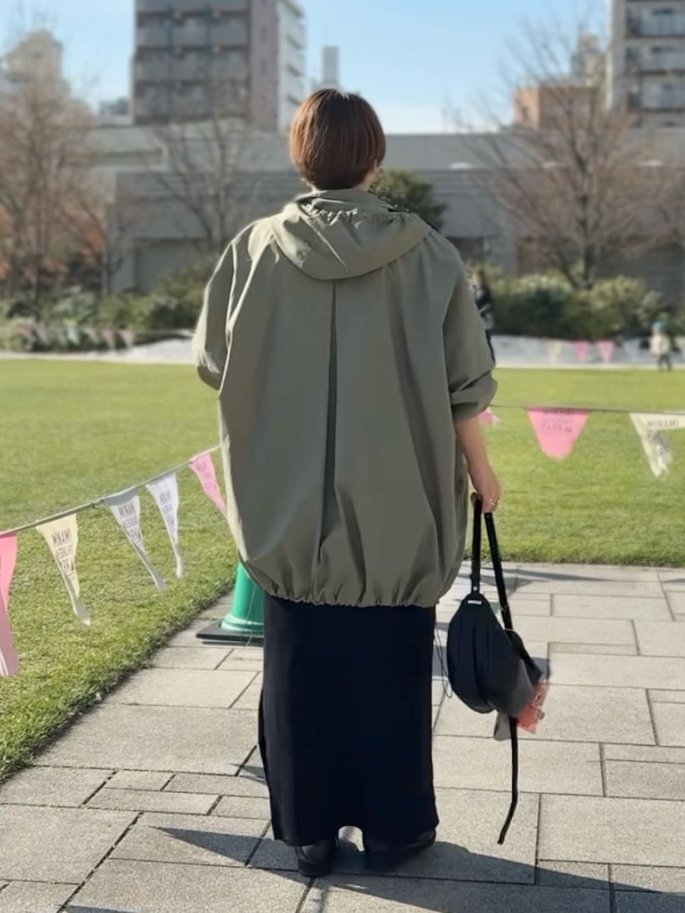 ブルー系のデニムスカート、ブラック系のワンピース、グリーン系のその他アウターを着用したレディースの冬コーディネートの3枚目の写真