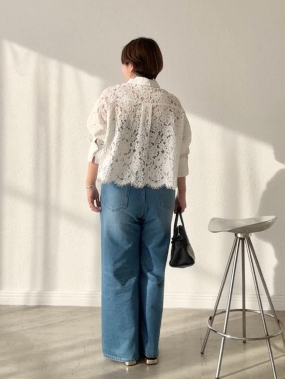 ホワイト系のシャツ/ブラウス、ブルー系のデニムパンツを着用したレディースの春コーディネートの2枚目の写真