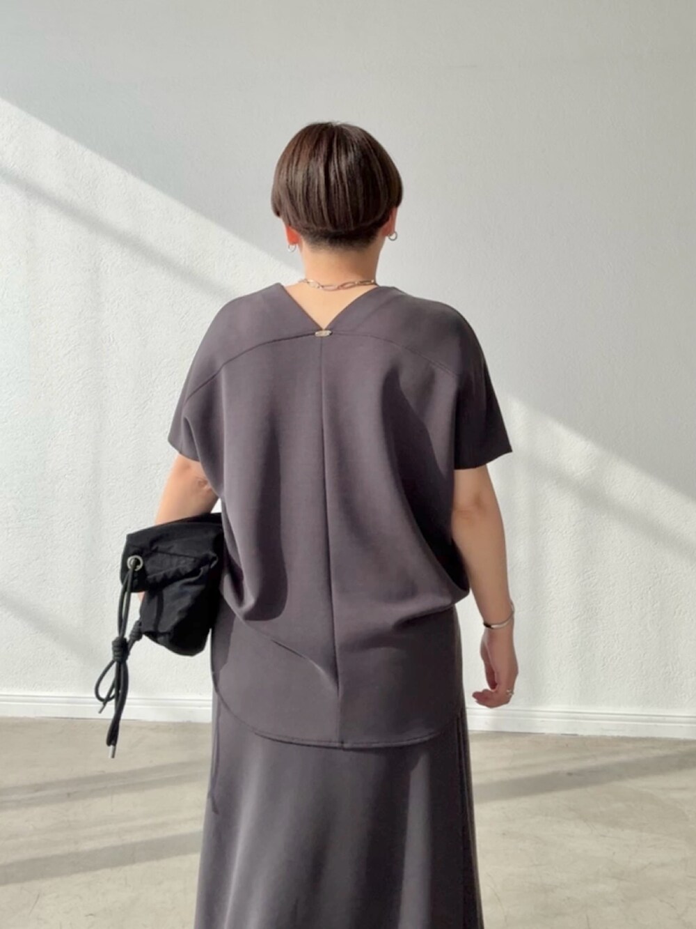 グレー系のTシャツ/カットソー、グレー系のスカートを着用したレディースの春コーディネートの4枚目の写真