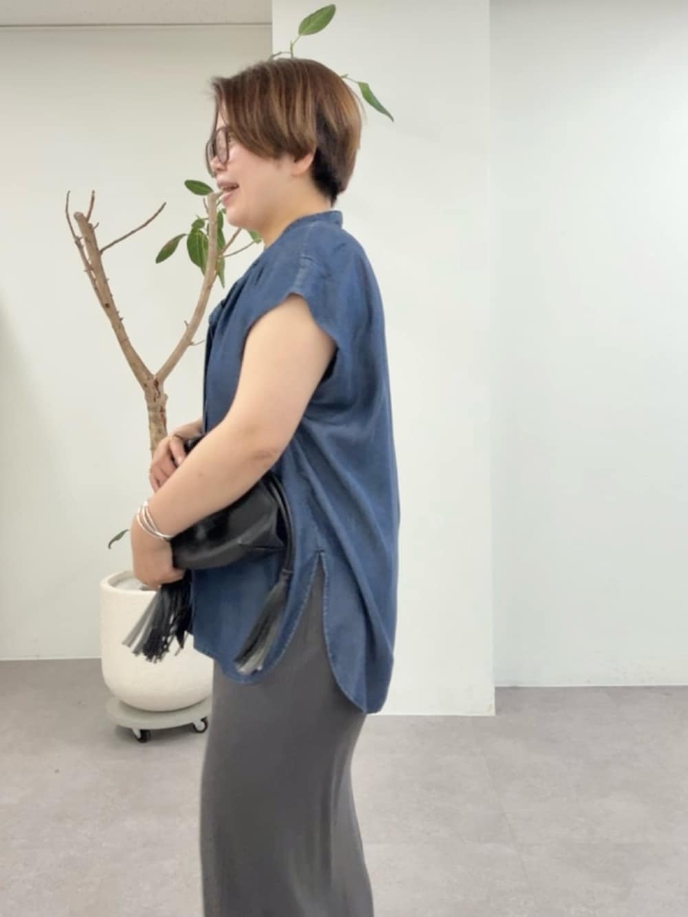 ブルー系のシャツ/ブラウス、グレー系のワンピース、ブラック系のショルダーバッグを着用したレディースの夏コーディネートの5枚目の写真