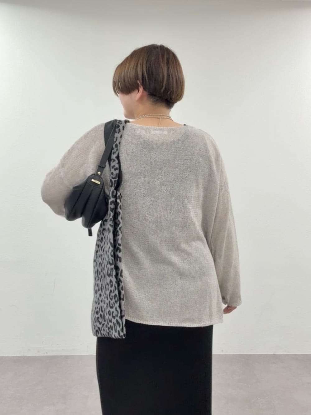 グレー系のニット/セーター、ブラック系のワンピースを着用したレディースの春コーディネートの5枚目の写真