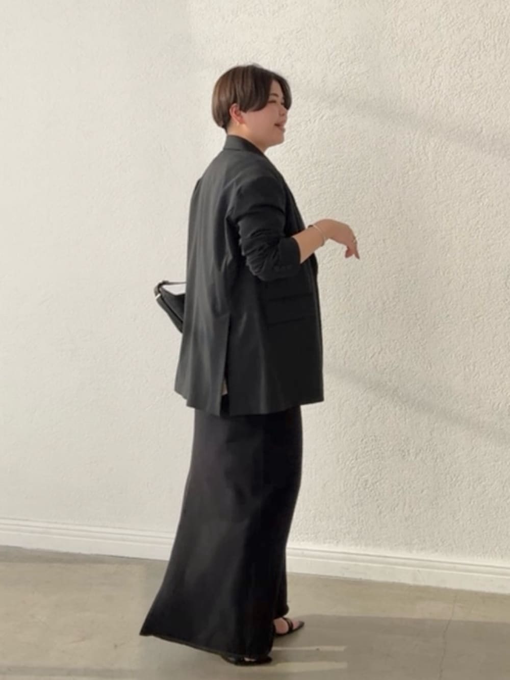 ブラック系のテーラードジャケット、ブラック系のスカート、ピンク系のTシャツ/カットソーを着用したレディースの春コーディネートの2枚目の写真