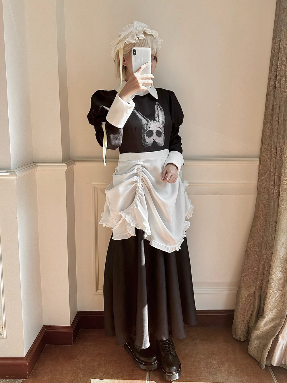 ブラック系のブーツ、ホワイト系の帽子を着用したレディースの冬コーディネートの2枚目の写真