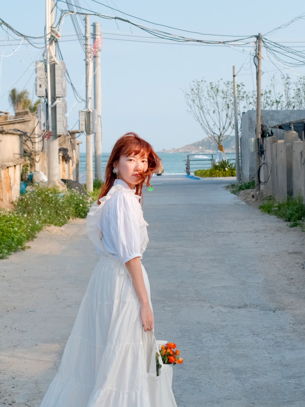 ホワイト系のトップス、ホワイト系のスカート、レッド系のローファーを着用したレディースの春コーディネートの2枚目の写真