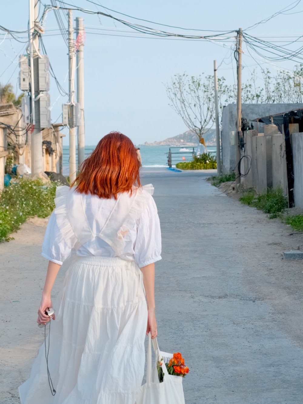 ホワイト系のトップス、ホワイト系のスカート、レッド系のローファーを着用したレディースの春コーディネートの3枚目の写真