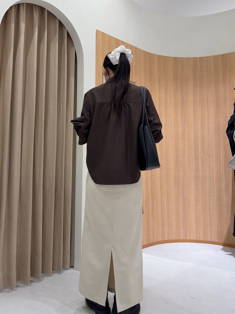 ホワイト系のスカート、ブラウン系のシャツ/ブラウス、ブラック系のショルダーバッグを着用したレディースの秋コーディネートの2枚目の写真