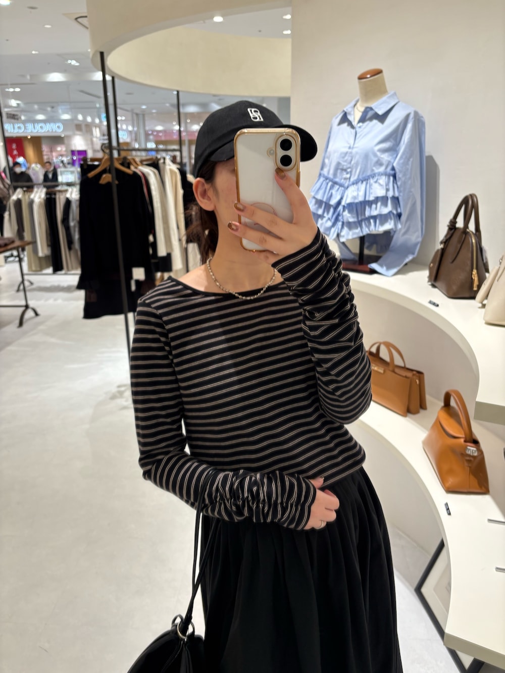 ブラック系のスカート、ブラック系のTシャツ/カットソー、ブラック系のショルダーバッグを着用したレディースの冬コーディネートの4枚目の写真
