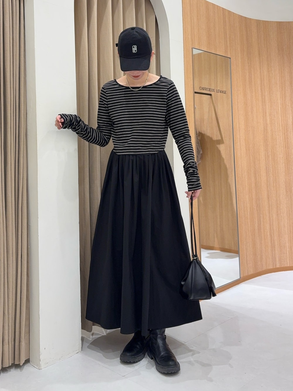 ブラック系のスカート、ブラック系のTシャツ/カットソー、ブラック系のショルダーバッグを着用したレディースの冬コーディネートの2枚目の写真