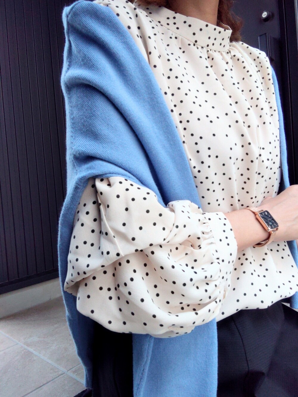 ブルー系のニット/セーター、ホワイト系のシャツ/ブラウス、ブラック系のスカートを着用したレディースの春コーディネートの3枚目の写真