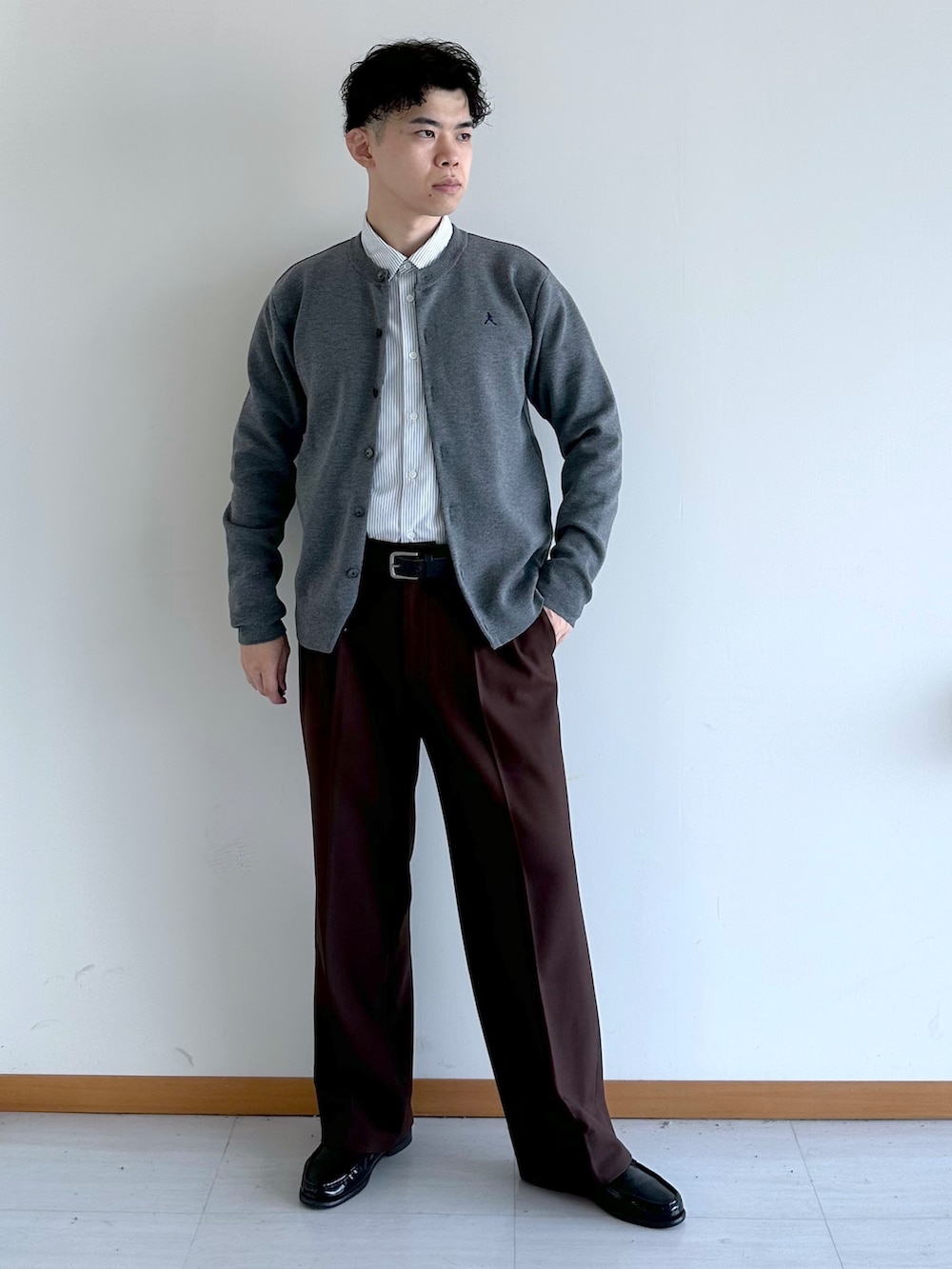 グレー系のカーディガン/ボレロ、ブルー系のシャツ/ブラウス、ブラウン系のスラックスを着用したメンズの秋コーディネートの2枚目の写真