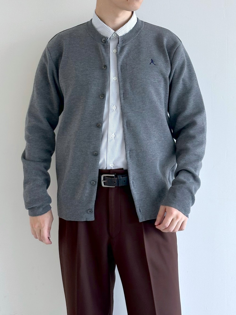 グレー系のカーディガン/ボレロ、ブルー系のシャツ/ブラウス、ブラウン系のスラックスを着用したメンズの秋コーディネートの5枚目の写真