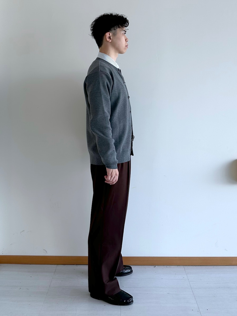 グレー系のカーディガン/ボレロ、ブルー系のシャツ/ブラウス、ブラウン系のスラックスを着用したメンズの秋コーディネートの3枚目の写真