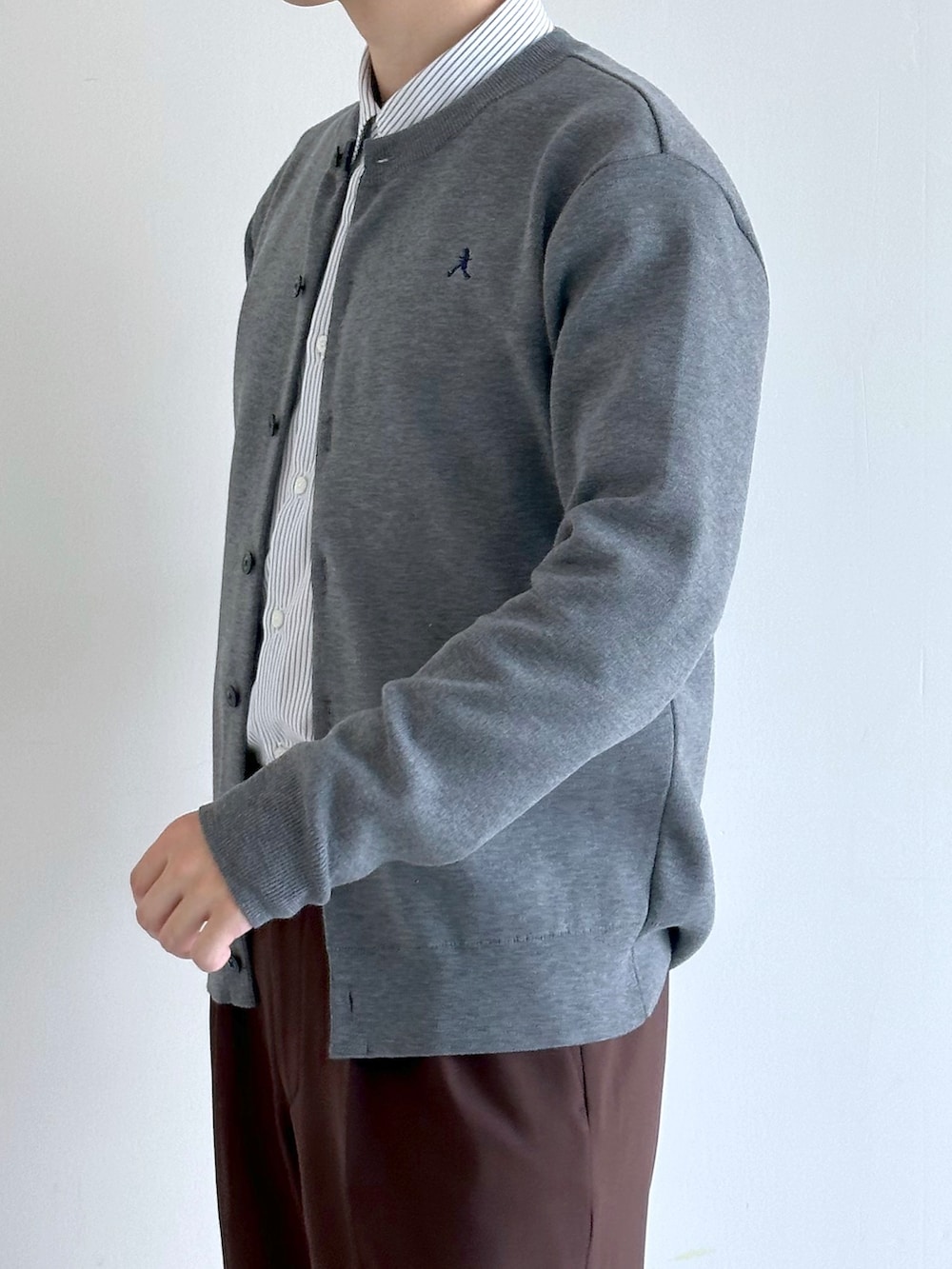グレー系のカーディガン/ボレロ、ブルー系のシャツ/ブラウス、ブラウン系のスラックスを着用したメンズの秋コーディネートの6枚目の写真
